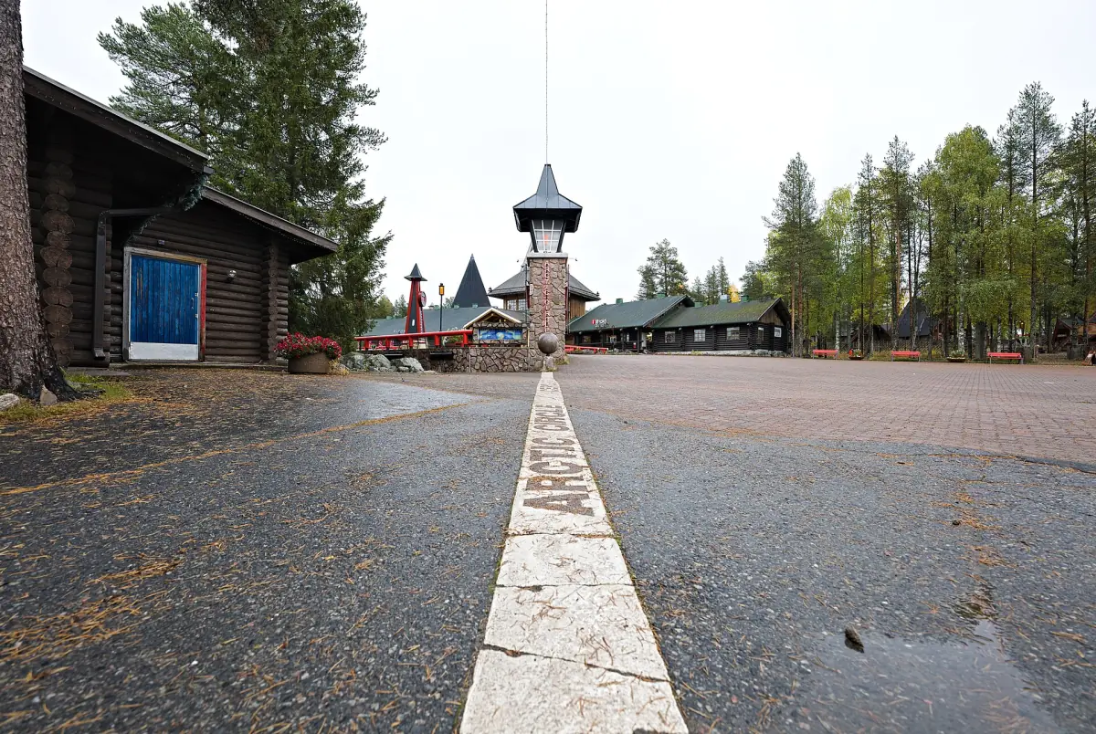 White Arctic Circle line running across the pavement toward a small tower