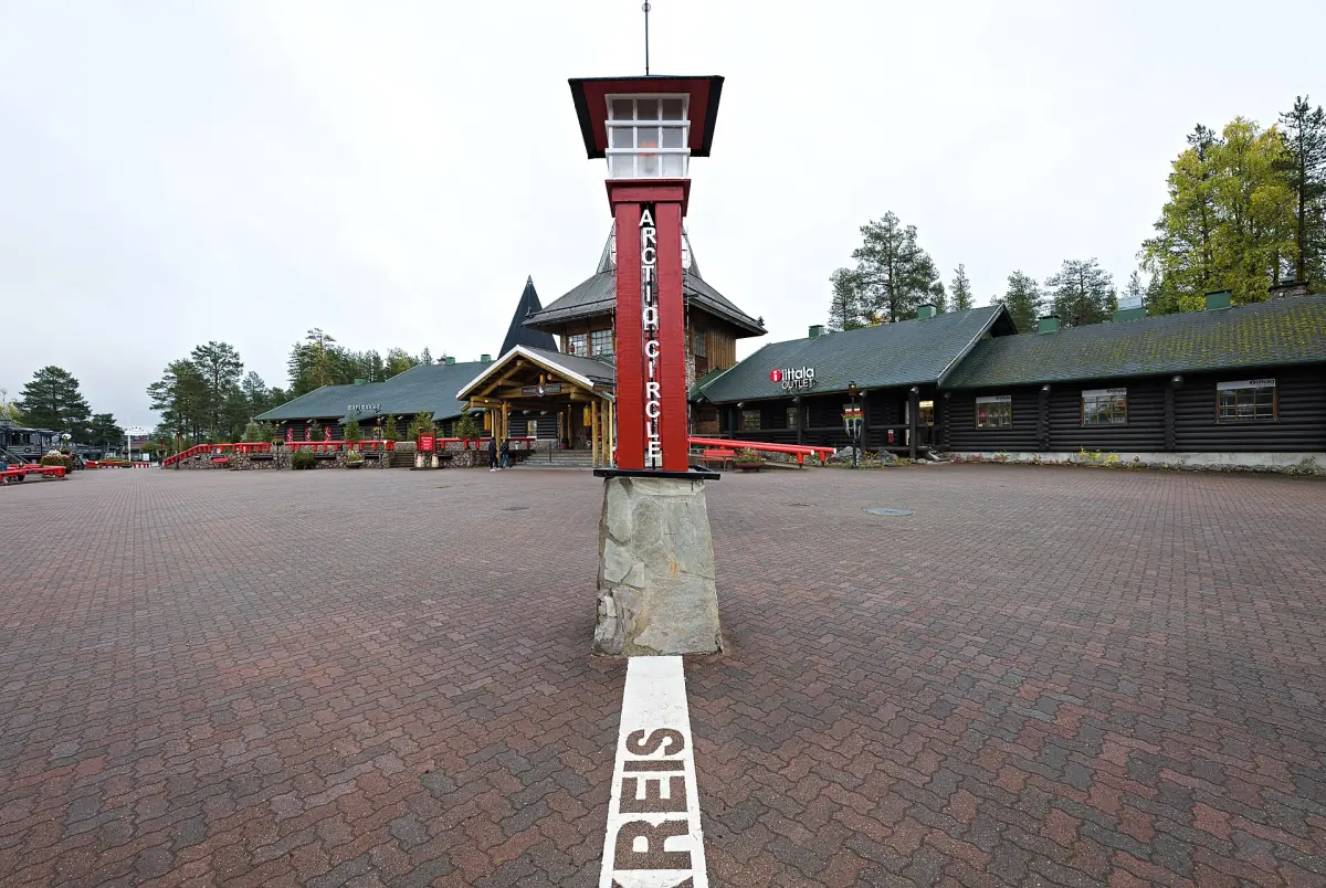 Red Arctic Circle marker tower with white line across the brick square