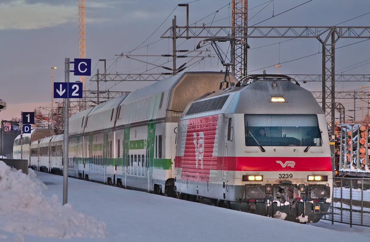 Double-decker passenger train at a snowy platform at Christmas time in Finland
