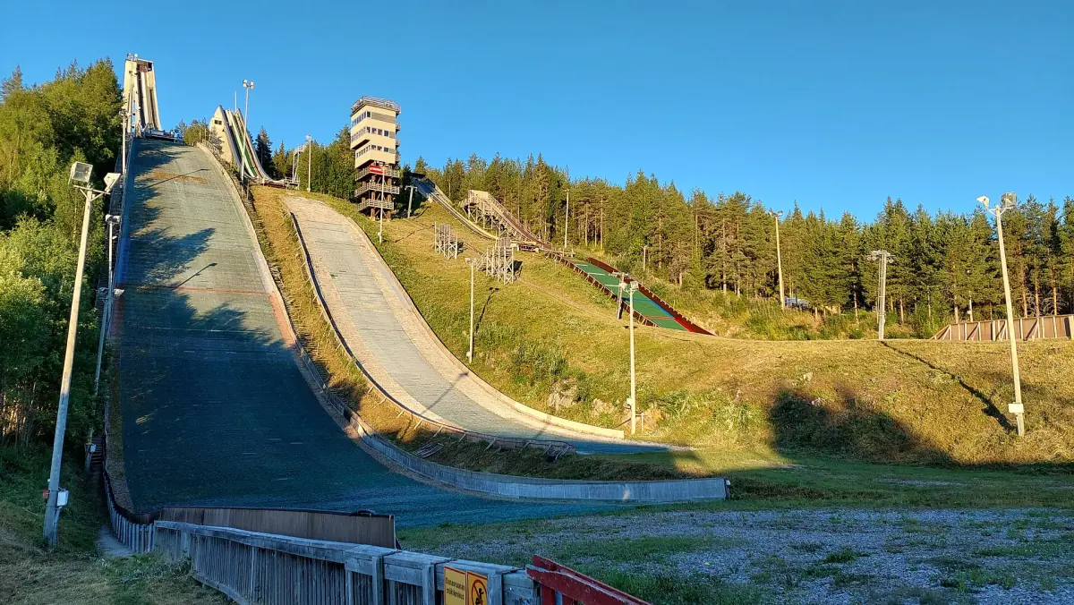 Ski jump hill and observation tower on Ounasvaara among pine forest in summer